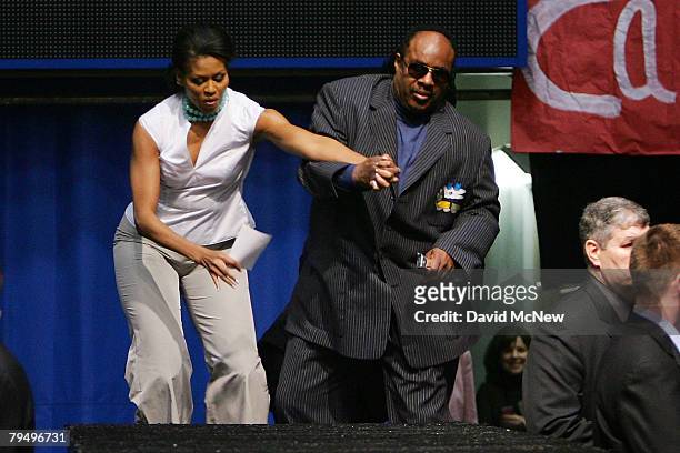 Musician Stevie Wonder falls while ascending backstage stairs with Michelle Obama, wife of Democratic presidential hopeful U.S. Sen. Barack Obama ,...