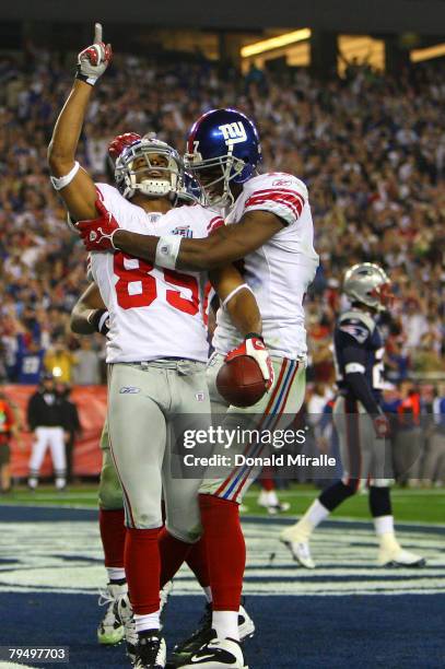 David Tyree of the New York Giants celebrates his five-yard touchdown reception with teammate Plaxico Burress in the fourth quarter against the New...