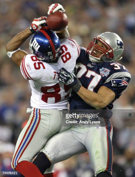 David Tyree of the New York Giants catches a 32-yard pass from Eli Manning as Rodney Harrison of the New England Patriots attempts to knock it out in...