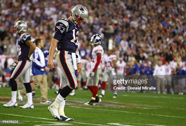 Quarterback Tom Brady of the New England Patriots walks off the field after losing to the New York Giants 17-14 in Super Bowl XLII on February 3,...