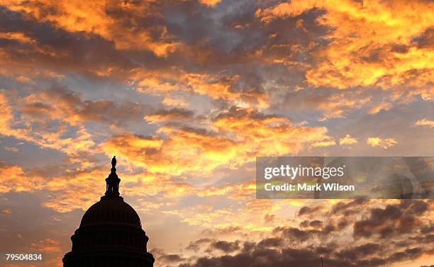 The early morning sky turns orange as the sun rises behind the U.S. Capitol building February 4, 2008 in Washington DC. U.S. President George W....