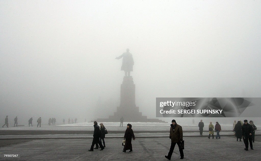 People pass Lenin's monument in the cent