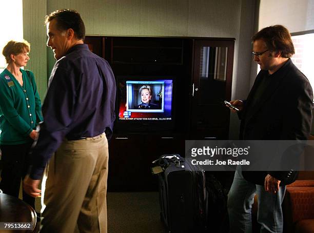Republican presidential hopeful and former Massachusetts Gov. Mitt Romney watches a newscast featuring Sen. Hillary Clinton during a campaign stop at...