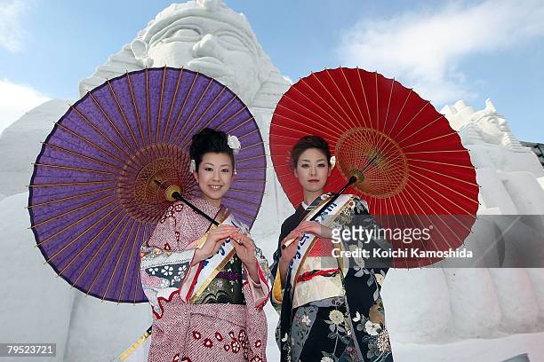 Miss Tokamachi, Akiko Suga and Mayumi Ota pose in front of the snow sculptures " Relics of Egypt " at Odori Park prepared for Sapporo Snow Festival...