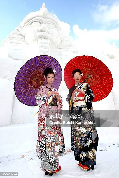 Miss Tokamachi, Akiko Suga and Mayumi Ota pose in front of the snow sculptures " Relics of Egypt " at Odori Park prepared for Sapporo Snow Festival...