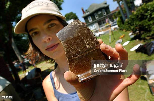 Brooklyn college student holds up a piece of a brown glazed bowl from the which she found during an archaeological dig in the yard of a church June...