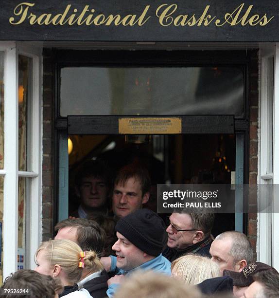 Pub customers watch as residents take part in the annual Shrovetide football match in Ashbourne, in Derbyshire, central England, February 5, 2008....