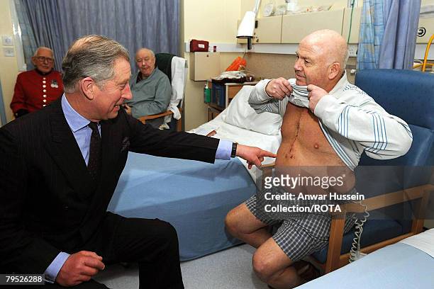 Prince Charles, Prince of Wales, looks at the scar of patient Anthony Stephens, who underwent an aortic valve replacement, during a visit to the...