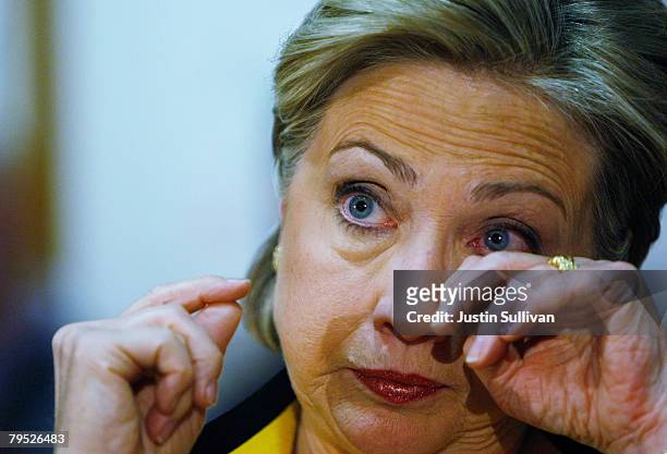 Democratic presidential hopeful U.S. Sen. Hillary Clinton wipes her eyes after they watered up from a coughing fit during a roundtable discussion at...
