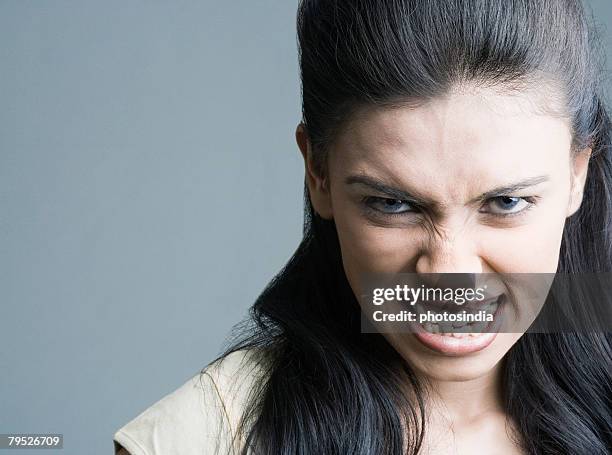 close-up of a young woman clenching her teeth - grimacing stock pictures, royalty-free photos & images