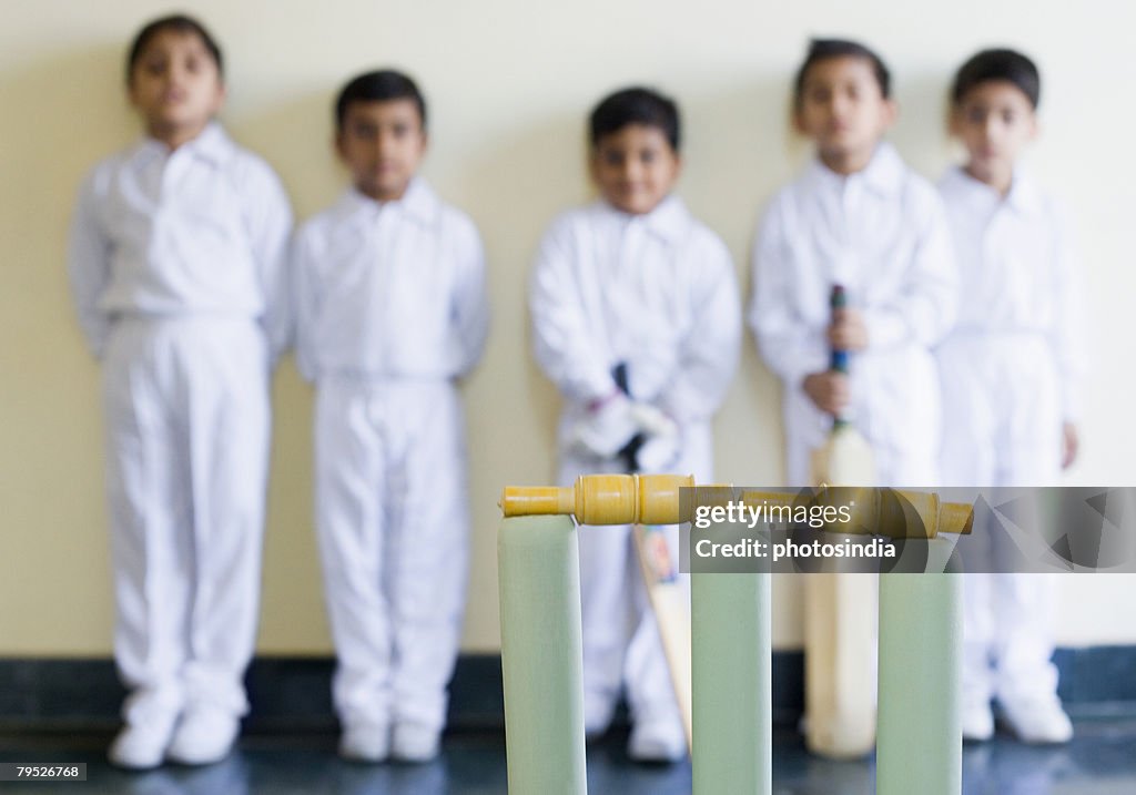 Close-up of cricket stump with cricket players standing in the background