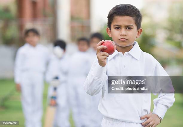cricketer holding a cricket ball - kids cricket stock pictures, royalty-free photos & images