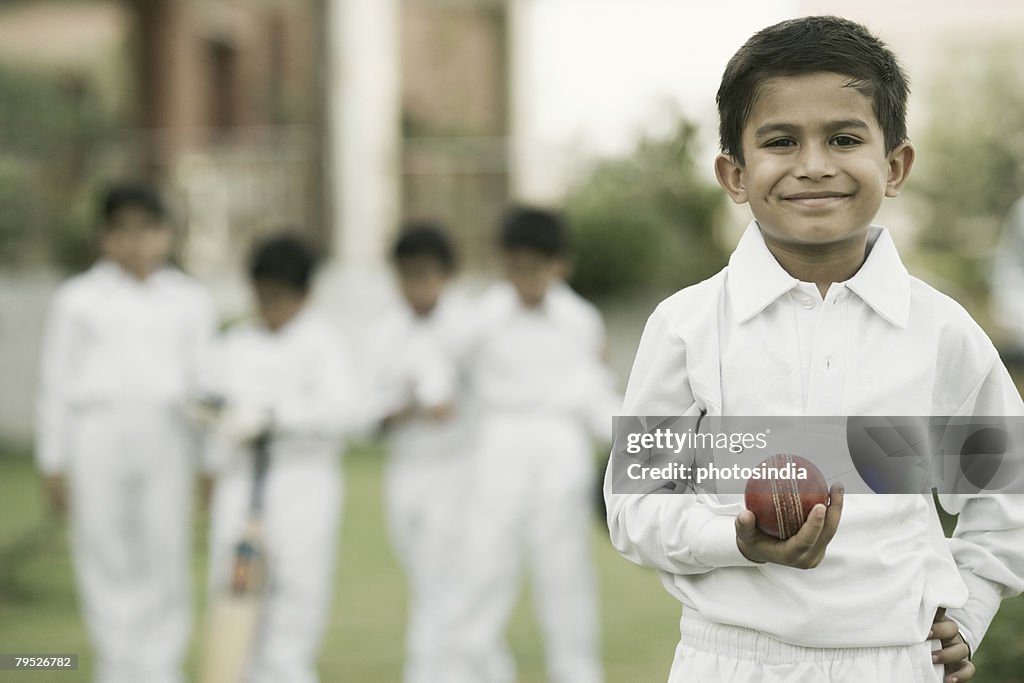 Cricketer holding a cricket ball and smiling