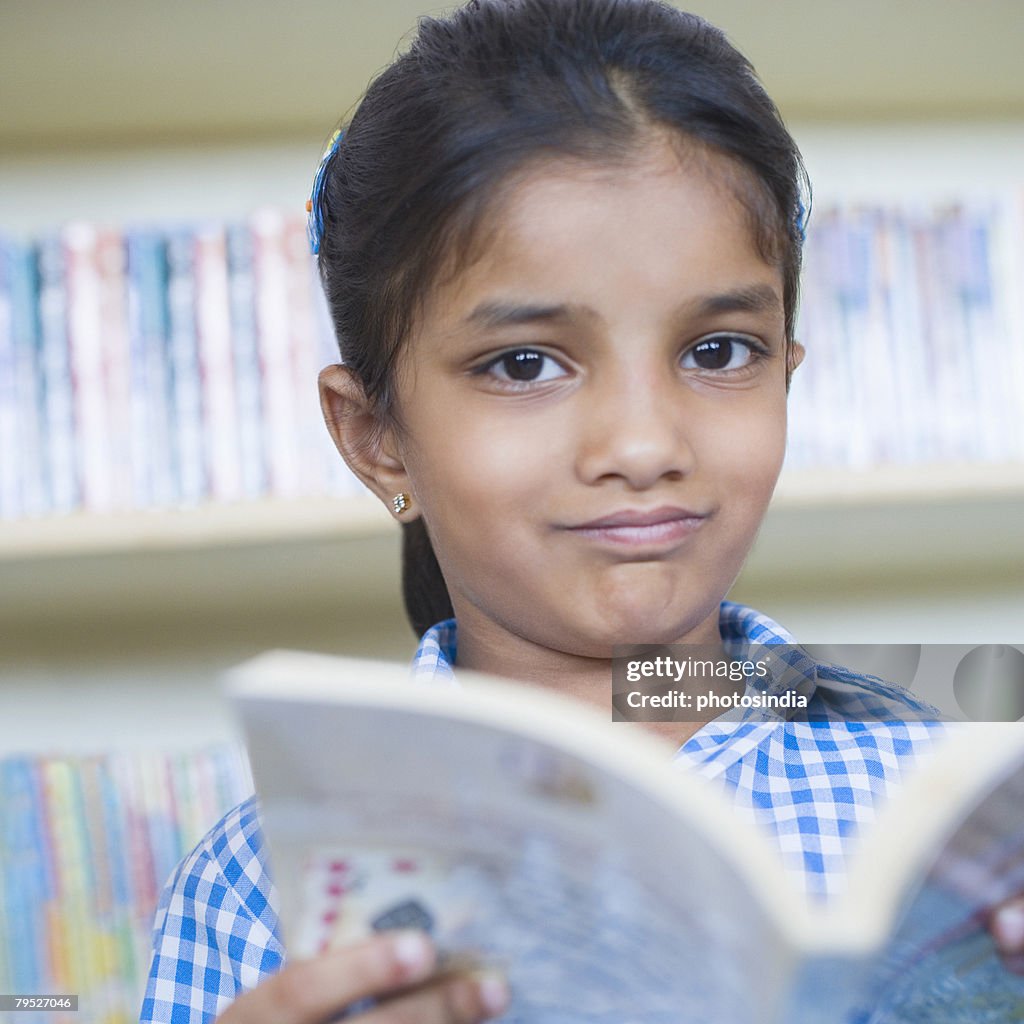 Portrait of a girl holding a book and making a face