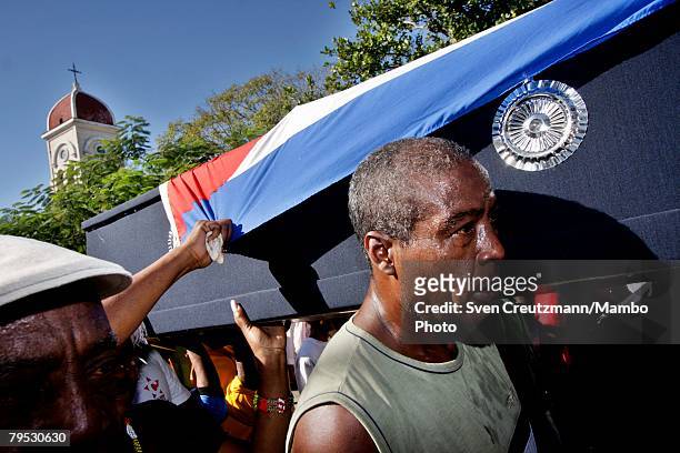 Cubans carry the coffin of Tata Guines, covered with a Cuban flag, through the streets of Guines on the way to the cementary, shortly before the...
