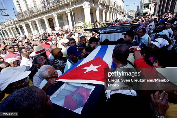 Cubans carry the coffin of Tata Guines, covered with a Cuban flag, through the streets of Guines on the way to the cementary, shortly before the...