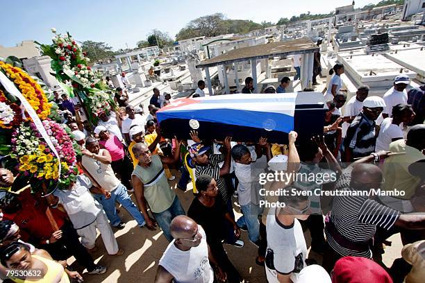 Cubans carry the coffin of Tata Guines, covered with a Cuban flag, through the streets of Guines on the way to the cementary, shortly before the...