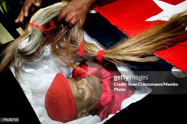 Cubans pass a horse's tail over the coffin of Tata Guines, an act of local religious significance, during the funeral of Frederico "Tata Guines"...