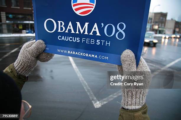 Mark Gustafson, a U.S. Sen. Barack Obama supporter and volunteer, holds a caucus sign in mittened hands, along Washington Avenue during Super Tuesday...