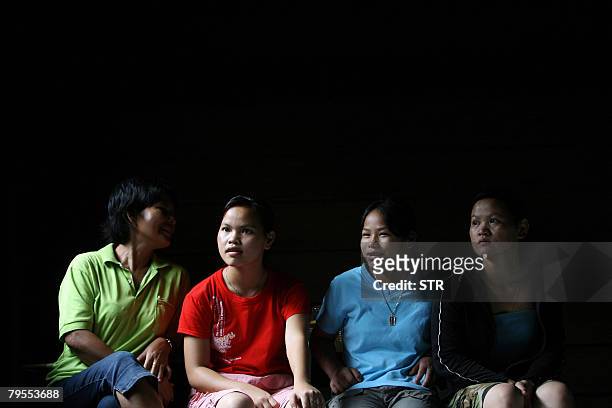 Malaysia-culture-environment-Penan by M. Jegathesan Young Penan tribeswomen chat as they take a break from household chores inside their house at...