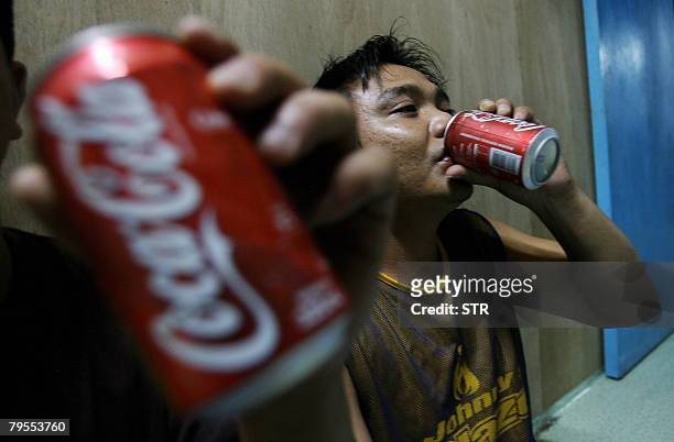 Malaysia-culture-environment-Penan by M. Jegathesan Penan tribesmen drink Coca-Cola at Long Main village, located in the Miri interior of Ulu Baram,...