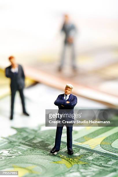 figurines standing on euro banknotes - valuta stock pictures, royalty-free photos & images