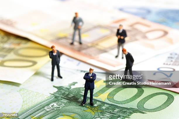 figurines standing on euro banknotes - eu trade stock pictures, royalty-free photos & images