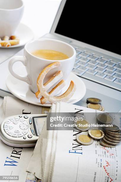 cup of coffee, euro cookie, coins, newspaper and mobile in front of laptop - valuta stock pictures, royalty-free photos & images