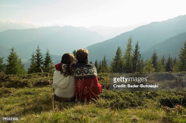 young couple sitting in mountains - kindness stock pictures, royalty-free photos & images