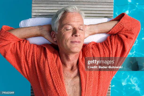 germany, senior man relaxing on float in pool, close-up, portrait - bademantel stock-fotos und bilder