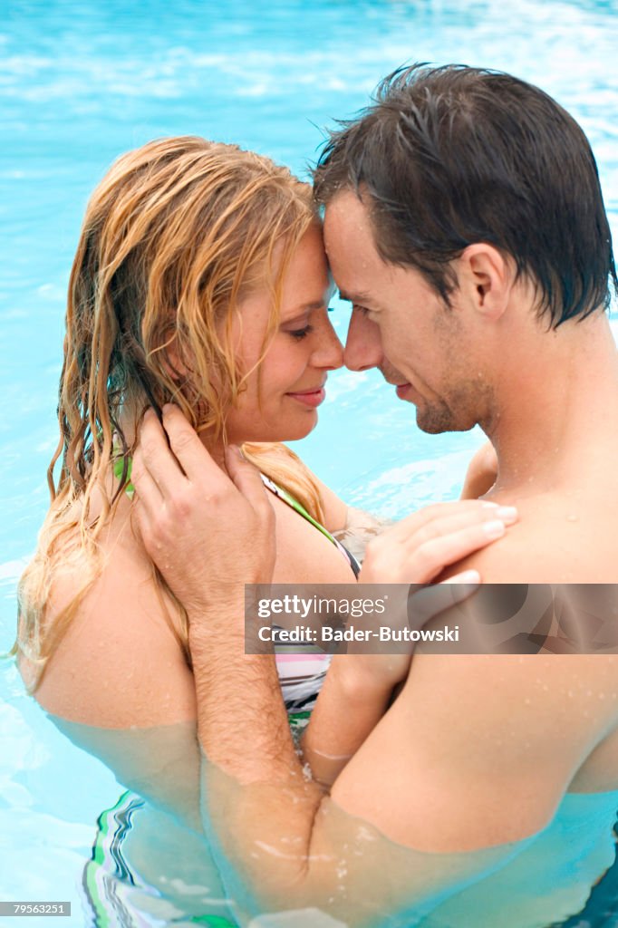 Germany, young couple embracing in swimming pool