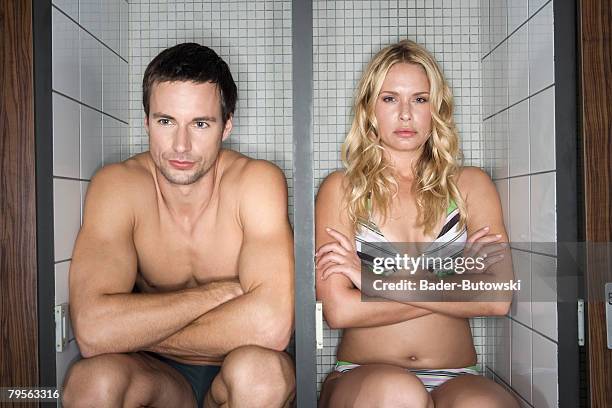 couple sitting in locker, arms crossed - mens changing room stock pictures, royalty-free photos & images