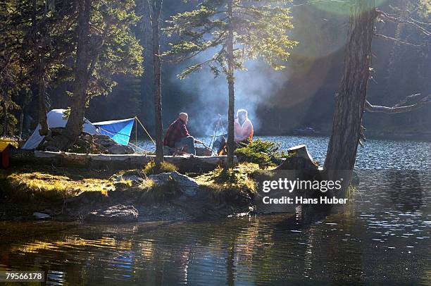 man and woman camping on small island - couple grilling stock-fotos und bilder