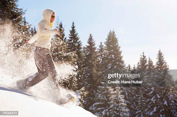 woman snowshoeing in mountains - schneeschuh stock-fotos und bilder