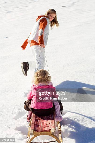 girl sitting on sledge, mother pulling - woman toboggan stock pictures, royalty-free photos & images