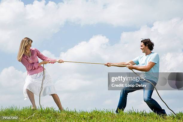 couple pulling rope, close-up - lucha de la cuerda fotografías e imágenes de stock