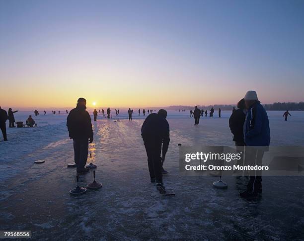 germany, bavaria, silhouette of people ice curling - curling fotografías e imágenes de stock