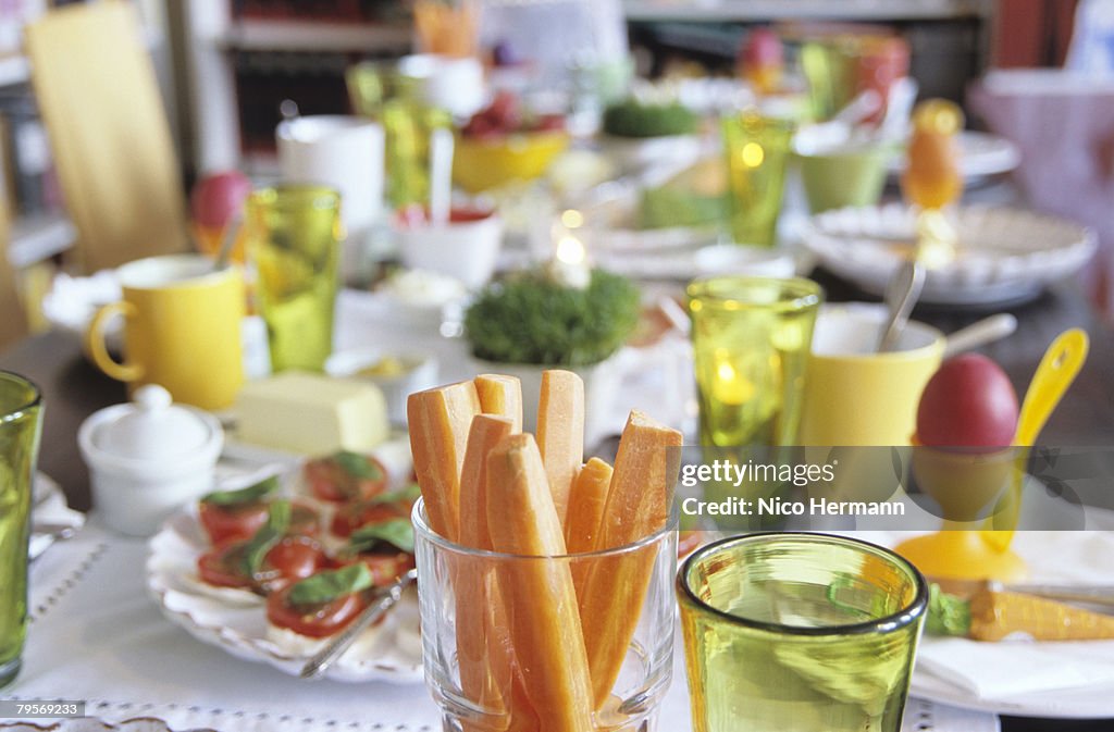 Easter table setting, focus on carrot slices in glass