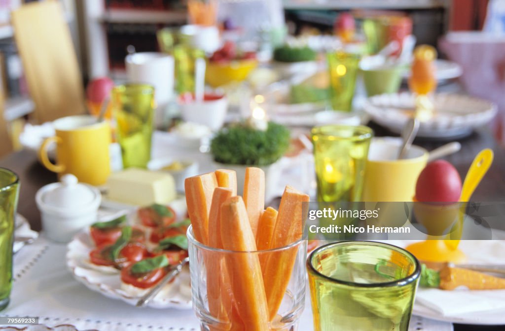 Easter table setting, focus on carrot slices in glass