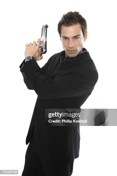 young man holding hand gun, close-up - holding hand gun stock pictures, royalty-free photos & images