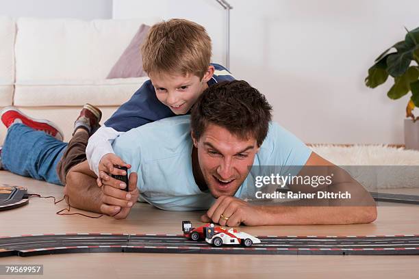 father and son (6-7) playing with toy cars - toy cars photos et images de collection