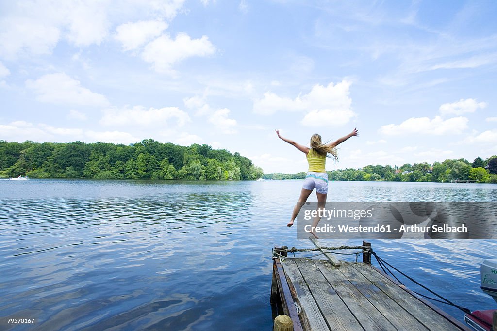 Woman Jumping into Lake, rear view