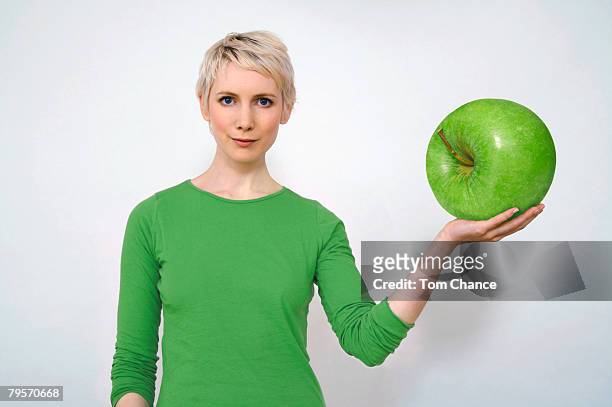 woman holding apple, close-up - big tom stock pictures, royalty-free photos & images