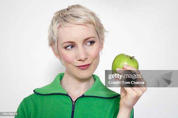 young woman holding apple, portrait - temptation apple stock pictures, royalty-free photos & images