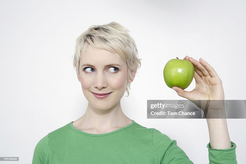 Young woman holding a green apple, portrait