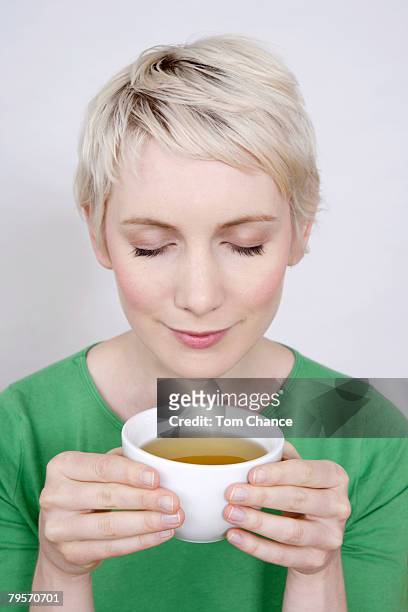 young woman holding tea bowl, portrait - cup portraits foto e immagini stock
