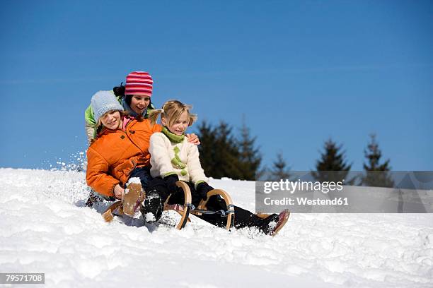 three children on sledge - effortless imagens e fotografias de stock