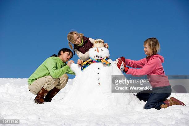girls building snowman - girl 11 12 laughing close up foto e immagini stock