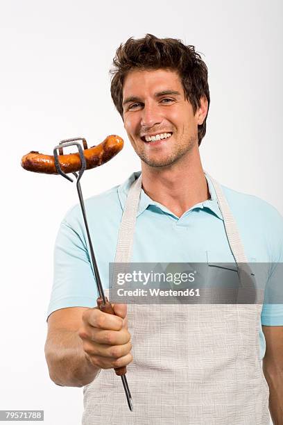 young man with grilled sausage - pinça utensílio de servir - fotografias e filmes do acervo