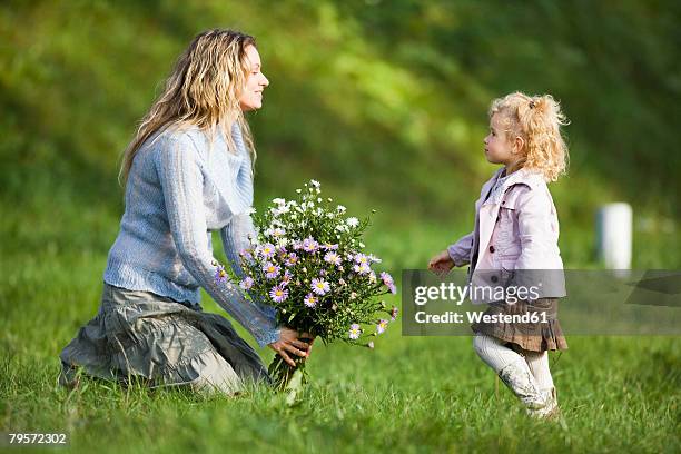 mother and daughter wirth bunch of flowers, side view - girl with legs open stock pictures, royalty-free photos & images